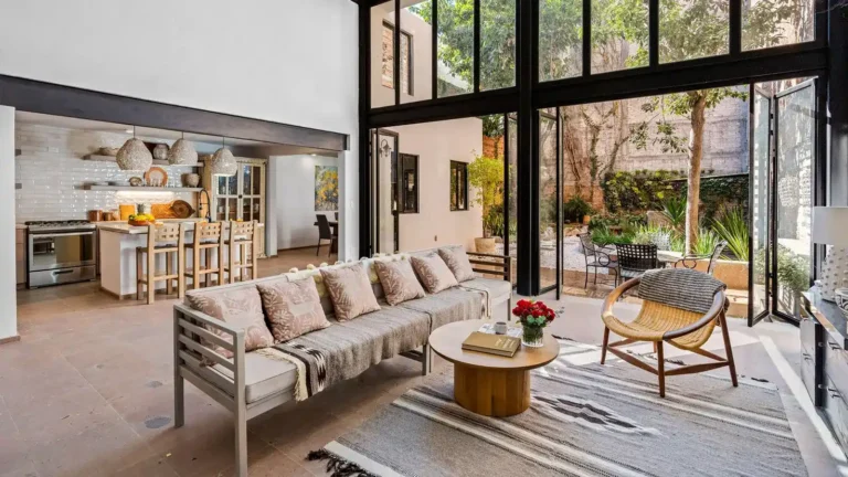 Modern luxury living room and open kitchen with floor-to-ceiling windows and garden views in San Miguel de Allende.
