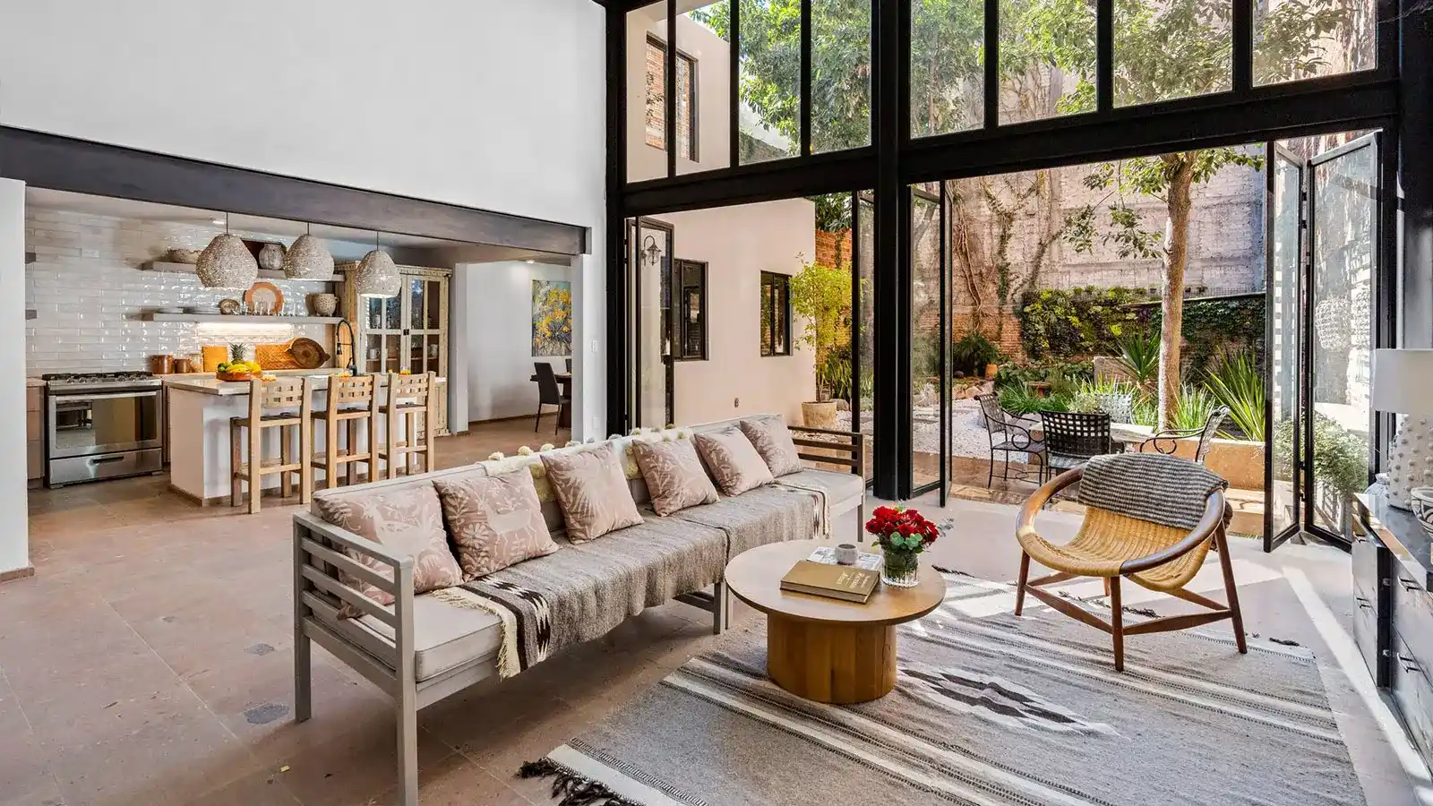 Modern luxury living room and open kitchen with floor-to-ceiling windows and garden views in San Miguel de Allende.