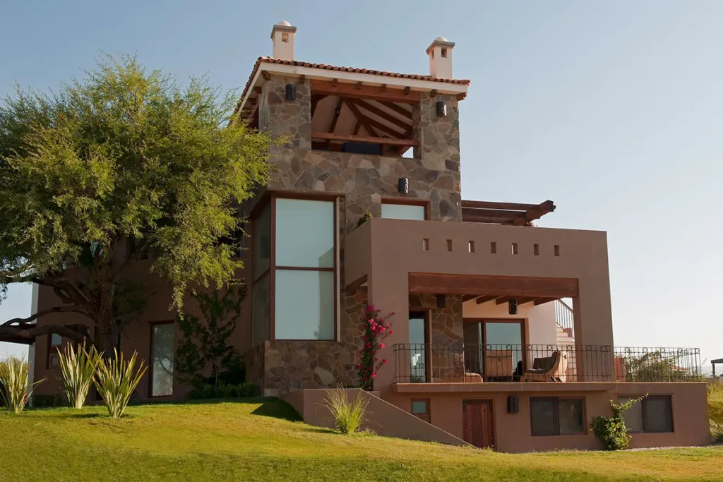 Modern luxury home in Las Ventanas Golf Club, San Miguel de Allende, featuring stone architecture, warm evening lighting, and a private pool.