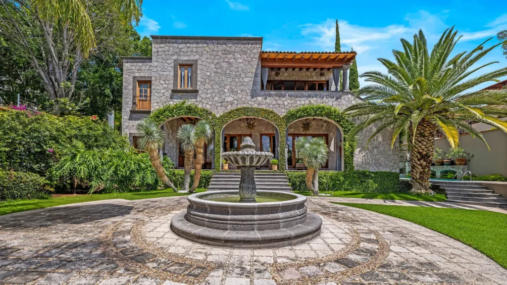 Colonial home in San Miguel de Allende with stone arches, fountain, and lush garden