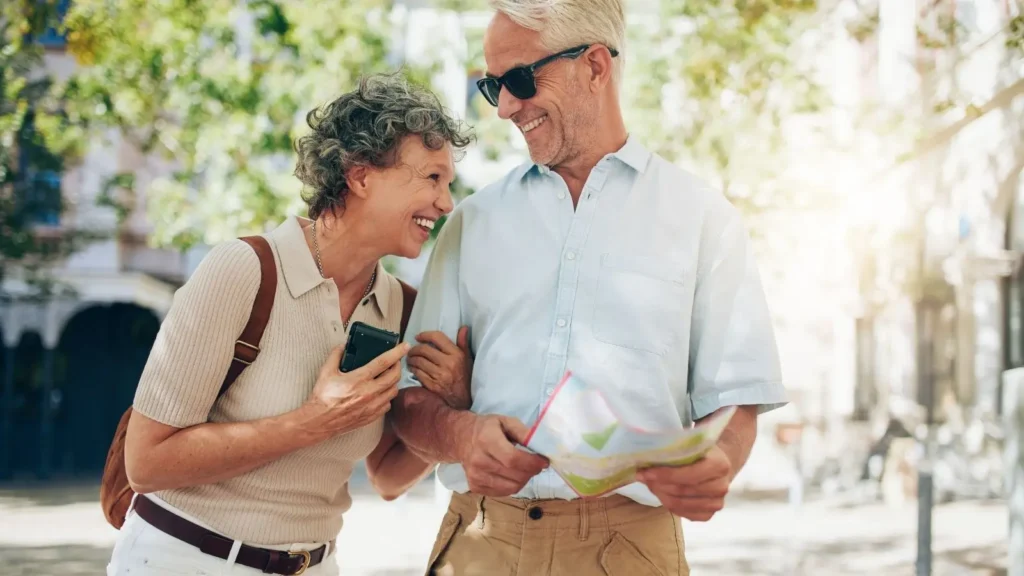 Happy retired couple exploring San Miguel de Allende with a map, enjoying outdoor city life as foreign residents in Mexico